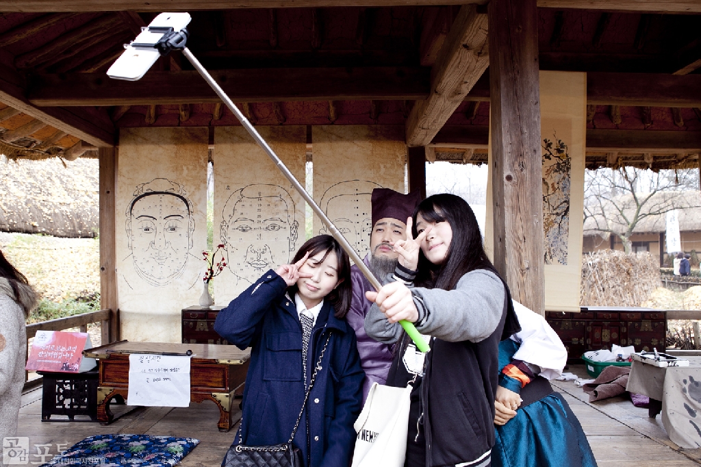 스크린과 브라운관을 종횡무진하고 있는 우리나라 사극을 체험해 볼 수 있는 '사극드라마축제'가 올해 3회를 맞이해 한국민속촌에서 개최되었다.</br>
민속촌 전체를 영화/드라마 속 배경으로 꾸미고 다양한 사극 체험행사를 마련하여 외국 관광객은 물론 국내 방문자에까지 많은 관심을 끌었다. 사진은 영화 <관상> 체험장의 관상가와 기념 촬영을 하고 있는 관람객.</br>
한국민속촌 정보 보기 : http://www.koreanfolk.co.kr/