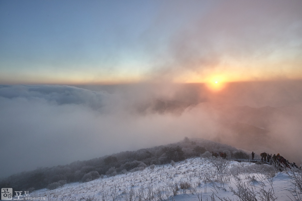 충북 단양과 경북 풍기 사이에 위치한 소백산 비로봉은 겨울 설산 트레킹의 성지로 꼽히고 있다. 멀리 구름 사이로 해가 떠오르고 있다. 