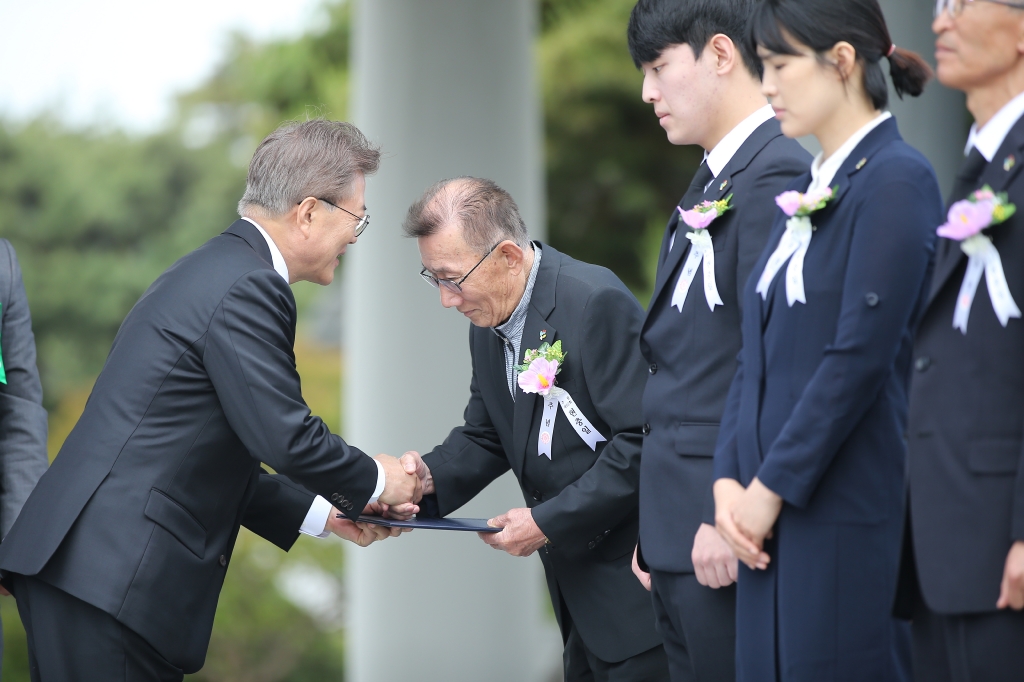 문재인 대통령이 6월 6일 오전 서울 동작구 국립서울현충원에서 열린 제62회 현충일 추념식에서 국가유공자들에게 국가유공자증서를 수여하고 있다.