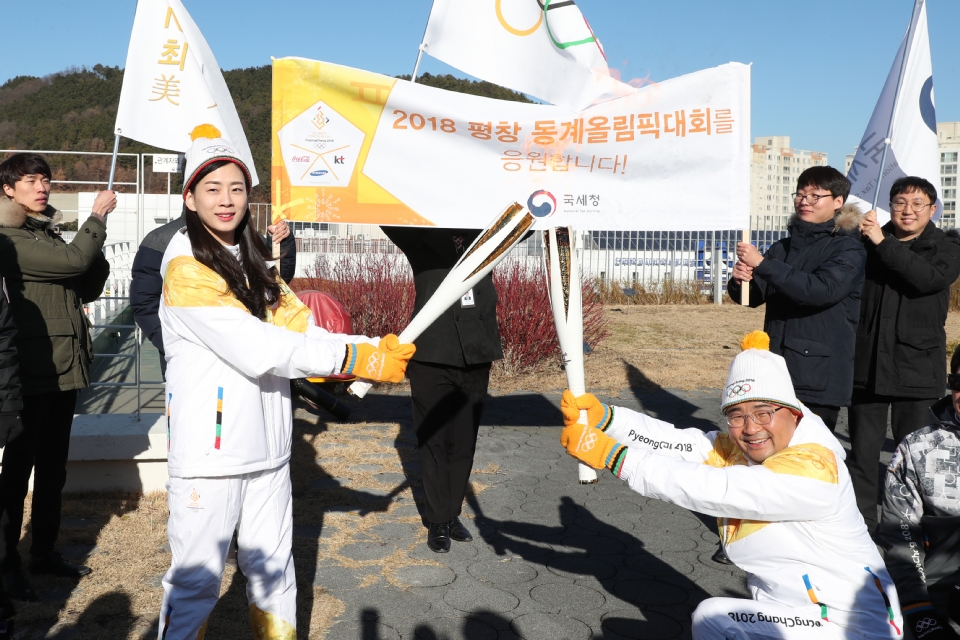 12월 13일 오후 세종특별자치시 정부세종청사 옥상정원에서 주자로 나선  세종청사에서 일하는 공무원들이 직장 선후배 및 기족들의 응원을 받으며 ‘2018 평창동계올림픽 성화 봉송’을 하고 있다. 이날 1동 국무총리실에서 시작해서 15동 문화체육관광부 옥상정원에서 성화봉송을 마무리하며 19명의 주자들이 기념촬영을 했다.