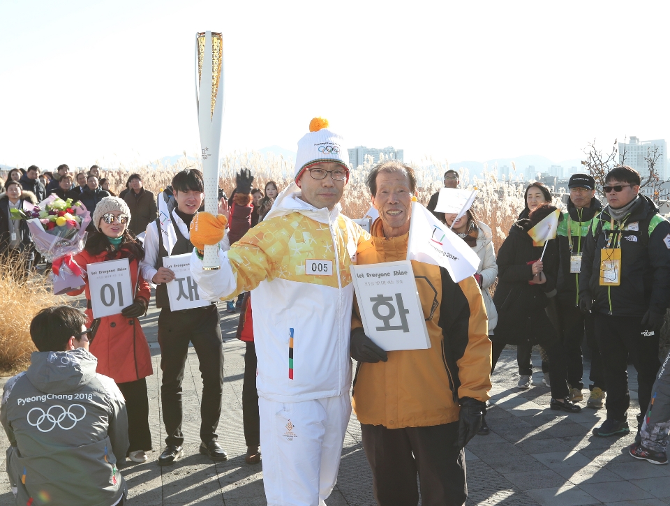 12월 13일 오후 세종특별자치시 정부세종청사 옥상정원에서 주자로 나선  세종청사에서 일하는 공무원들이 직장 선후배 및 기족들의 응원을 받으며 ‘2018 평창동계올림픽 성화 봉송’을 하고 있다. 이날 1동 국무총리실에서 시작해서 15동 문화체육관광부 옥상정원에서 성화봉송을 마무리하며 19명의 주자들이 기념촬영을 했다.