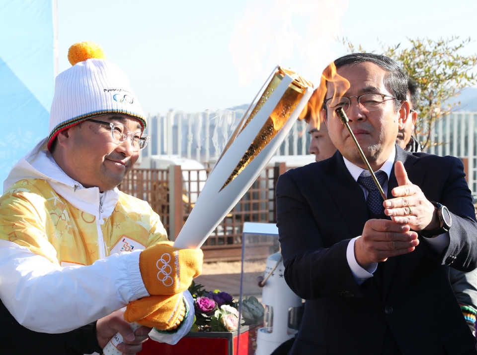 12월 13일 오후 세종특별자치시 정부세종청사 옥상정원에서 주자로 나선  세종청사에서 일하는 공무원들이 직장 선후배 및 기족들의 응원을 받으며 ‘2018 평창동계올림픽 성화 봉송’을 하고 있다. 이날 1동 국무총리실에서 시작해서 15동 문화체육관광부 옥상정원에서 성화봉송을 마무리하며 19명의 주자들이 기념촬영을 했다.