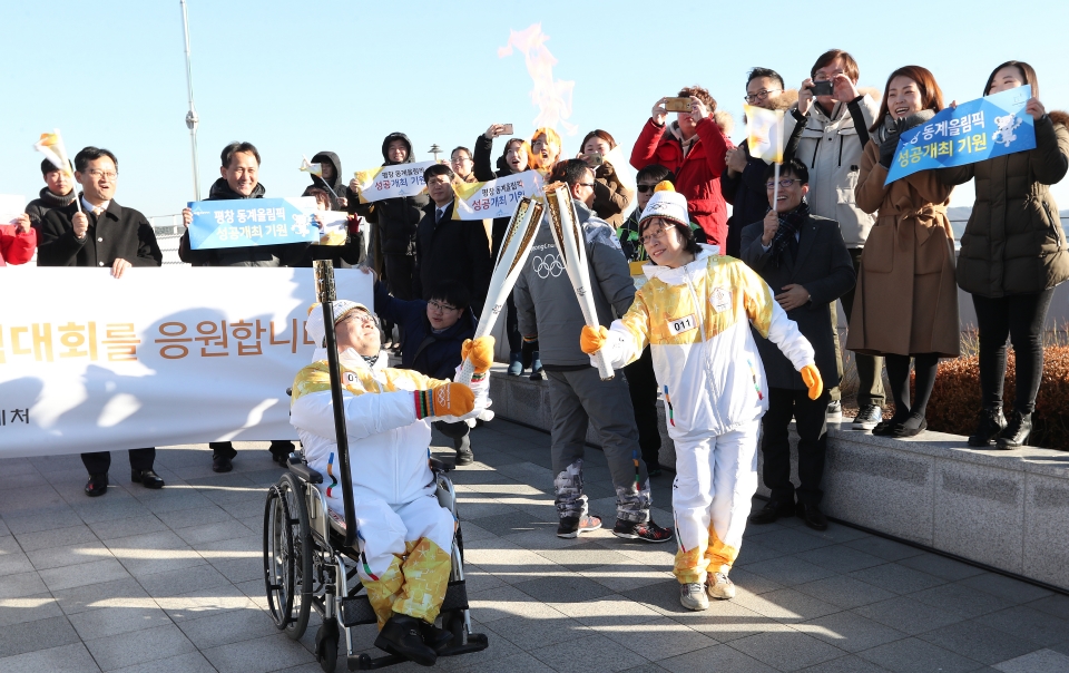 12월 13일 오후 세종특별자치시 정부세종청사 옥상정원에서 주자로 나선  세종청사에서 일하는 공무원들이 직장 선후배 및 기족들의 응원을 받으며 ‘2018 평창동계올림픽 성화 봉송’을 하고 있다. 이날 1동 국무총리실에서 시작해서 15동 문화체육관광부 옥상정원에서 성화봉송을 마무리하며 19명의 주자들이 기념촬영을 했다.