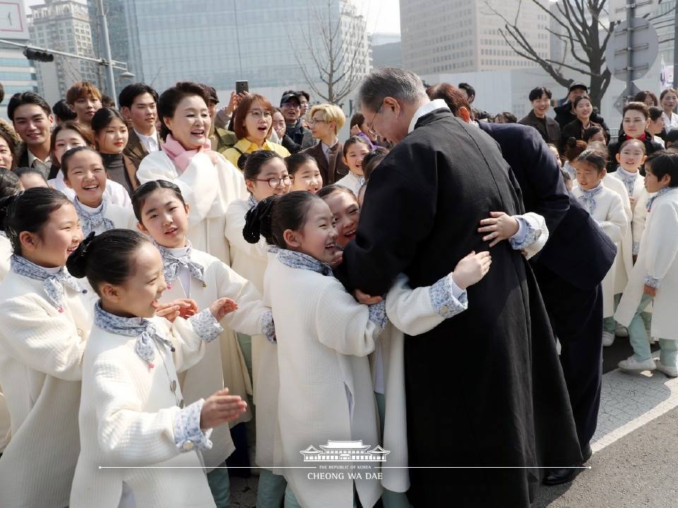 문재인 대통령과 부인 김정숙 여사가 1일 오전 서울 광화문에서 열린 제100주년 3.1절 기념식을 마친 뒤 행사에 출연한 어린이들과 포옹하고 있다. (사진출처 : 청와대 페이스북)