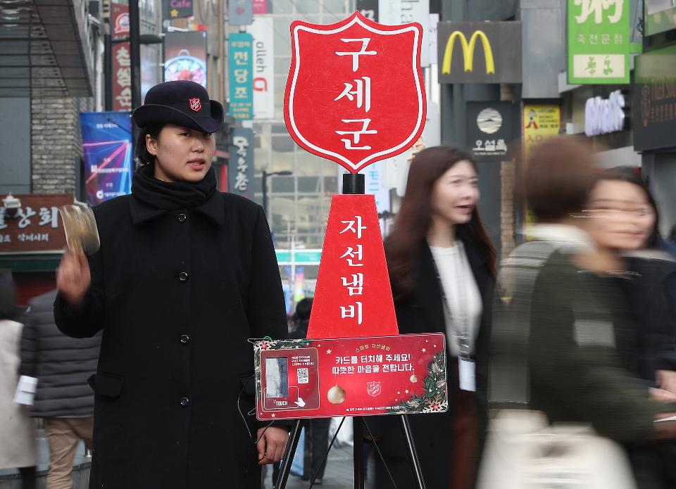 11일 구세군사관학교 학생이 서울 명동거리에 설치된 자선냄비 앞에서 모금 봉사활동을 펼치고 있다. 모금기간은 올해 12월 31일까지이며 전국 17개 시,도에 353개의 자선냄비가 설치되어 모금활동을 펼칠 예정이다.