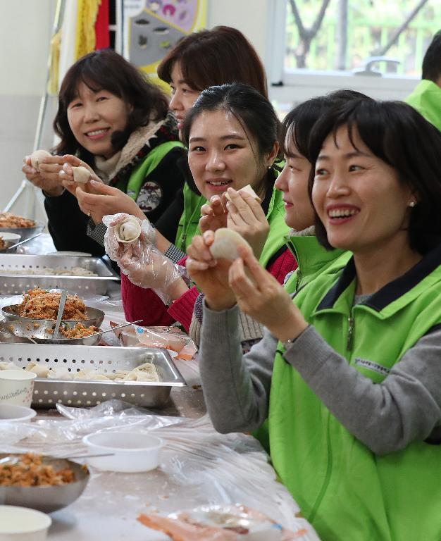 22일 설을 앞두고 강동송파교육지원청 관내 교직원 120여 명이 서울 송파구 잠현초등학교 구내식당에서 강동송파지역복지센터를 통해 인근 어르신들에게 전달 할 사랑의 만두를 빚고 있다. 