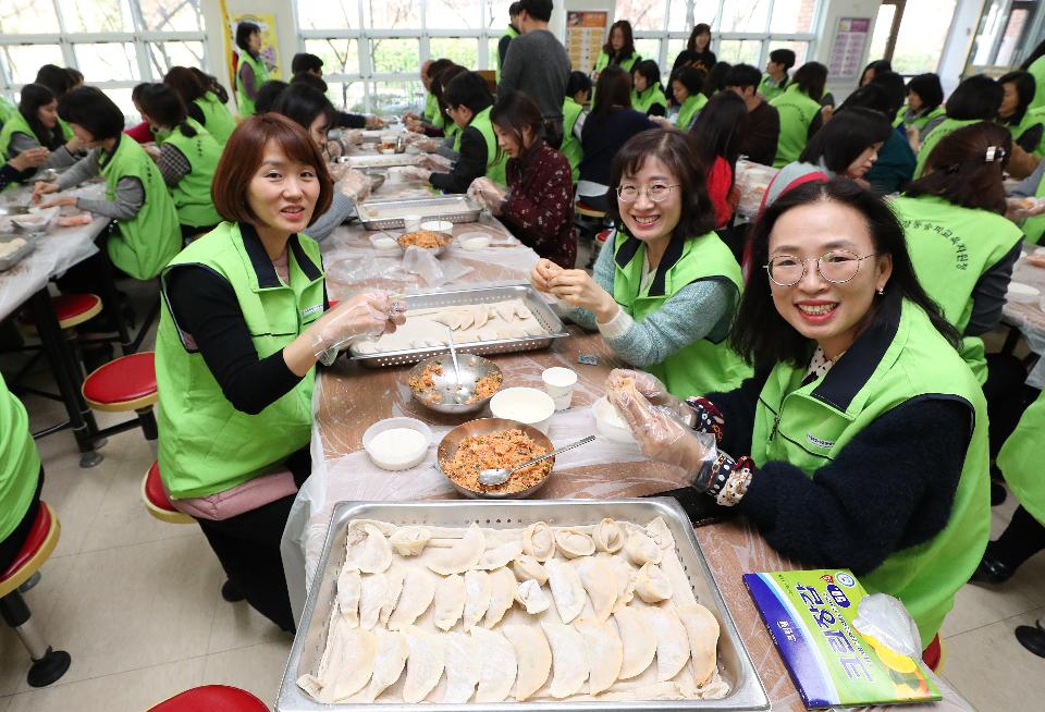 22일 설을 앞두고 강동송파교육지원청 관내 교직원 120여 명이 서울 송파구 잠현초등학교 구내식당에서 강동송파지역복지센터를 통해 인근 어르신들에게 전달 할 사랑의 만두를 빚고 있다. 