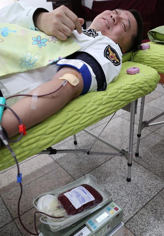 18일 신종 코로나바이러스 감염증(코로나19)에 따른 혈액 수급난 해소를 위해 서울 서대문구 경찰청 공무원들이 경찰청 강당에서 사랑 나눔 헌혈 운동에 참여하고 있다.