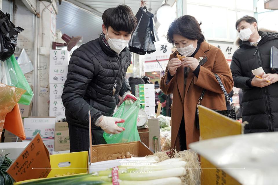 문재인 대통령의 부인 김정숙 여사가 18일 오후 신종 코로나바이러스 감염증(코로나19)으로 위축된 소비심리 활성화를 위해 서울 중랑구 동원전통종합시장을 방문, 생강을 구매하고 있다.