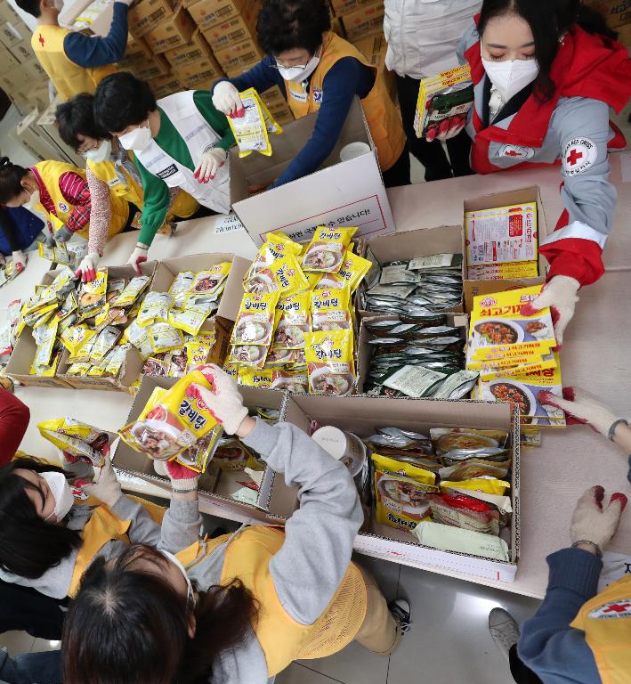 27일 서울 성동구 대한적십자사 서울특별시지사에서 대한적십자 직원 및 봉사자들이 코로나19 대응 서울시내 재난취약계층에게 전달할 긴급구호품을 제작하고 있다. 이날 주부식 14종 및 마스크 9개가 들어간 900박스를 제작했으며 3월 25일부터 오늘까지 5,000박스 제작을 완료할 예정이다.