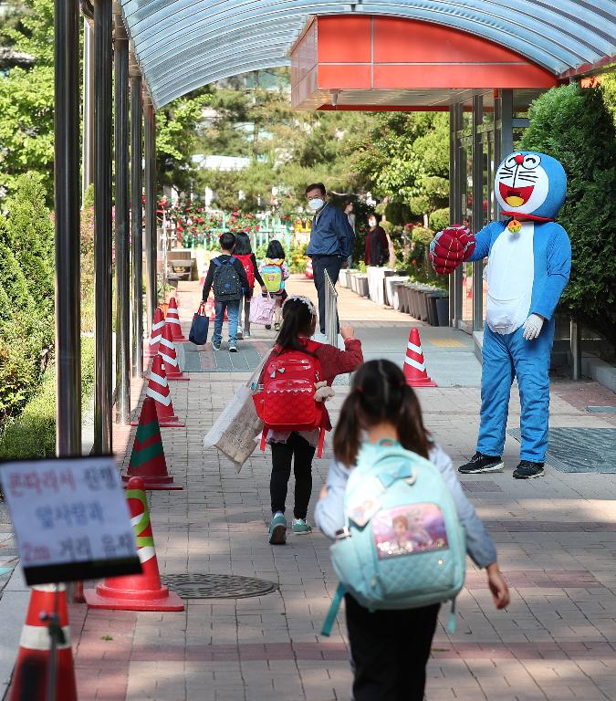 <p>27일 서울 동작구 보라매초등학교 1학년, 2학년 학생들이 코로나19 예방을 위해 선생님들의 안내로 후문과 정문을 통해 일정한 거리두기와 발열 체크를 하며 침착하게 등교해 수업에 참여하고 있다. 이날 교장선생님이 인기 있는 만화캐릭터 복장을 하고 학생들과 등교 인사를 하고 있다.</p>