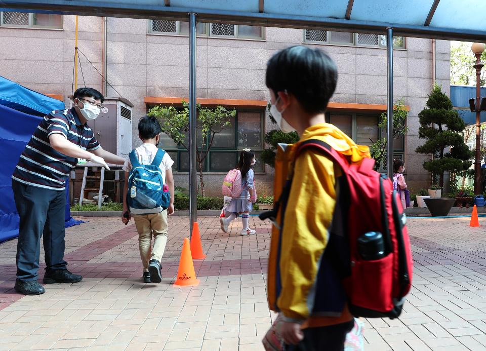 <p>27일 서울 동작구 보라매초등학교 1학년, 2학년 학생들이 코로나19 예방을 위해 선생님들의 안내로 후문과 정문을 통해 일정한 거리두기와 발열 체크를 하며 침착하게 등교해 수업에 참여하고 있다. 이날 교장선생님이 인기 있는 만화캐릭터 복장을 하고 학생들과 등교 인사를 하고 있다.</p>