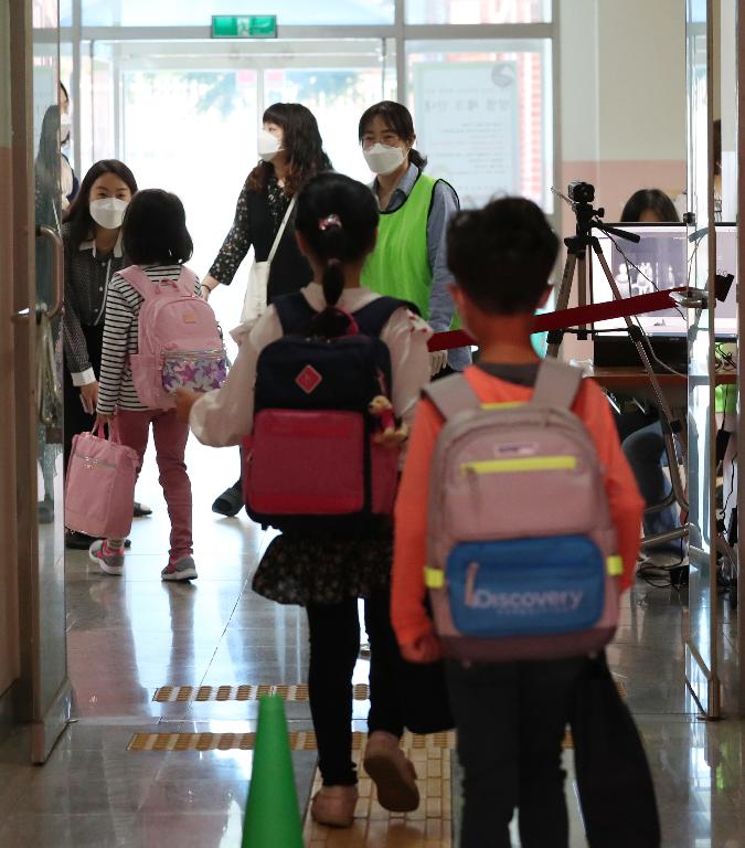 <p>27일 서울 동작구 보라매초등학교 1학년, 2학년 학생들이 코로나19 예방을 위해 선생님들의 안내로 후문과 정문을 통해 일정한 거리두기와 발열 체크를 하며 침착하게 등교해 수업에 참여하고 있다. 이날 교장선생님이 인기 있는 만화캐릭터 복장을 하고 학생들과 등교 인사를 하고 있다.</p>