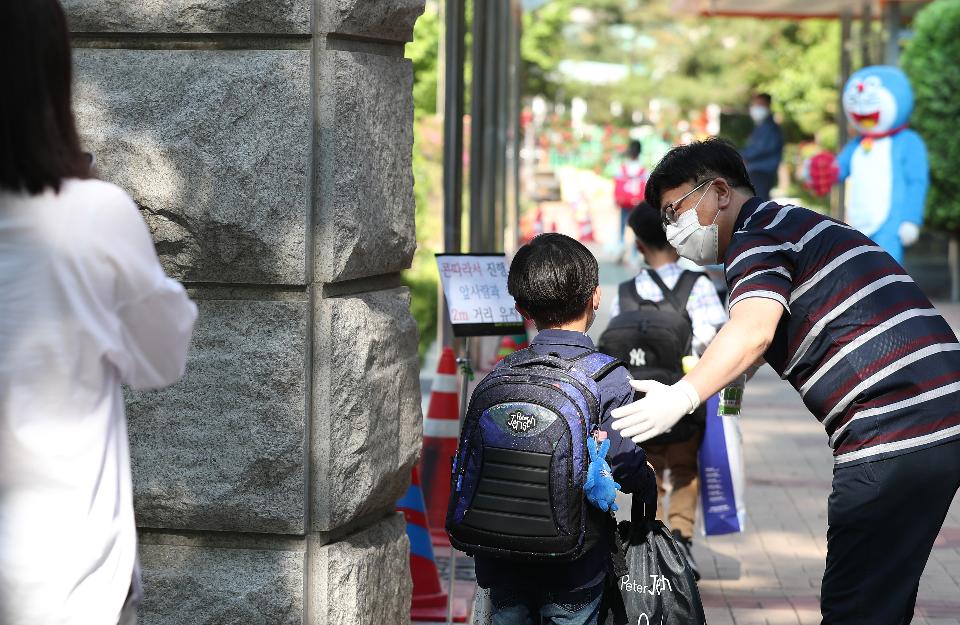 <p>27일 서울 동작구 보라매초등학교 1학년, 2학년 학생들이 코로나19 예방을 위해 선생님들의 안내로 후문과 정문을 통해 일정한 거리두기와 발열 체크를 하며 침착하게 등교해 수업에 참여하고 있다. 이날 교장선생님이 인기 있는 만화캐릭터 복장을 하고 학생들과 등교 인사를 하고 있다.</p>