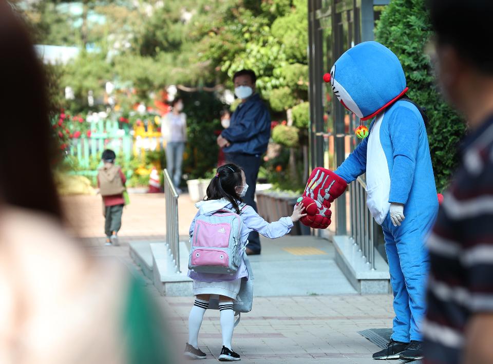 <p>27일 서울 동작구 보라매초등학교 1학년, 2학년 학생들이 코로나19 예방을 위해 선생님들의 안내로 후문과 정문을 통해 일정한 거리두기와 발열 체크를 하며 침착하게 등교해 수업에 참여하고 있다. 이날 교장선생님이 인기 있는 만화캐릭터 복장을 하고 학생들과 등교 인사를 하고 있다.</p>