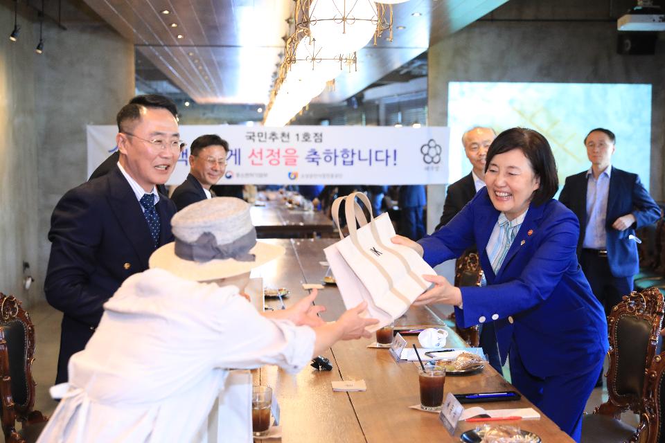 박영선 중소벤처기업부 장관이 백년가게(태극당) 현판식에 참석한 이부영 선동보리밥대표에게 브랜드k 기념품을 전달하고 있다.