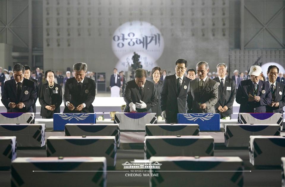 문재인 대통령이 25일 경기 성남 서울공항에서 열린 6.25전쟁 70주년 행사에 참석해 국군 전사자들의 유해함에 참전기장을 수여하고 있다.
