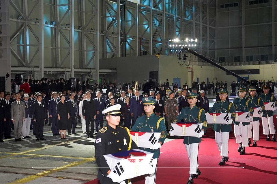 문재인 대통령이 25일 경기 성남 서울공항에서 열린 6.25전쟁 70주년 행사에서 참석자들과 함께 국군전사자 유해 봉송 모습을 바라보고 있다.