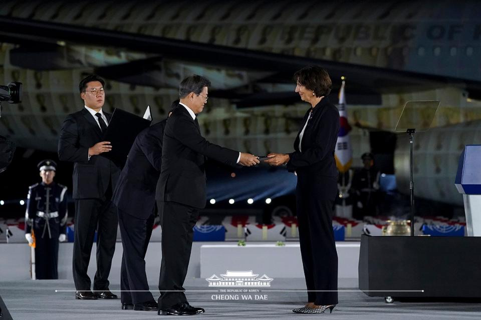 문재인 대통령이 25일 경기 성남 서울공항에서 열린 6.25전쟁 70주년 행사에서 요안나 돌너왈드 주한네덜란드대사에게 평화의 패를 수여하고 있다.