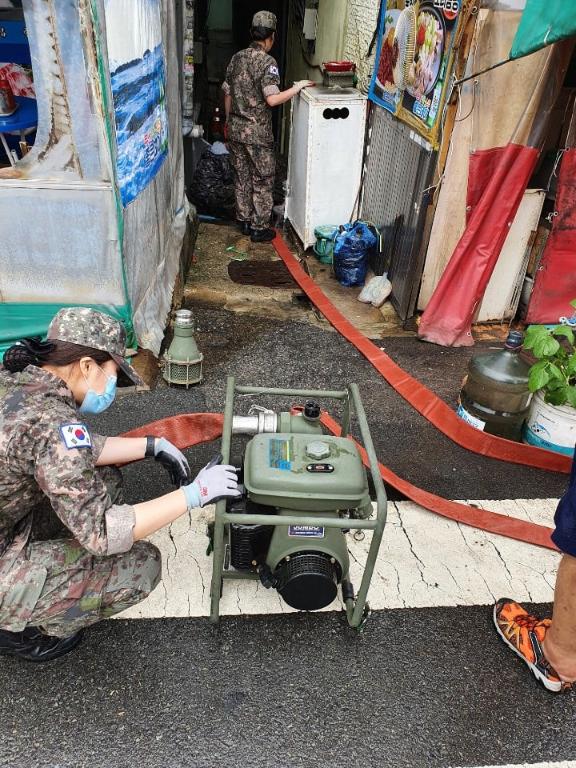 <p>10일 부산지역에 200mm가 넘는 집중호우가 발생해 해군작전사령부 기지방호전대 소속 장병들이 긴급 대민 복구작업을 진행했다. 침수피해를 입은 부대 인근 민가에 장병들이 투입되어 양수기, 소방차를 활용한 지원과 함께 공간상 어려운 곳은 직접 양동이를 나르며 배수작업을 지원했다.</p>