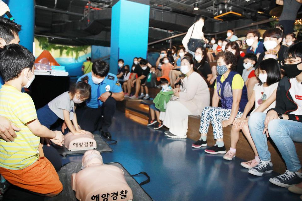 <p>해양경찰청 경찰관이 롯데월드 아쿠아리움에서 열린 ‘2020년 여름 해양안전교실’에서 심폐소생술, 구명조끼 착용법 등 안전 교육을 진행하고, 참가자들과 ‘구명조끼 해(海)주세요’ 캠페인을 하고 있다.</p>