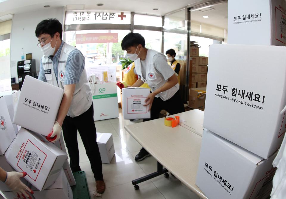 <p>17일 서울 성동구 대한적십자사 서울지사에서 적십자 직원 및 봉사원들이 전국 수해 가구에 전달할 추석구호세트 1,300여 개를 제작해 트럭에 싣고 있다. 구호세트는 마스크, 손소독제, 가공식품 등으로 구성되었다.</p>