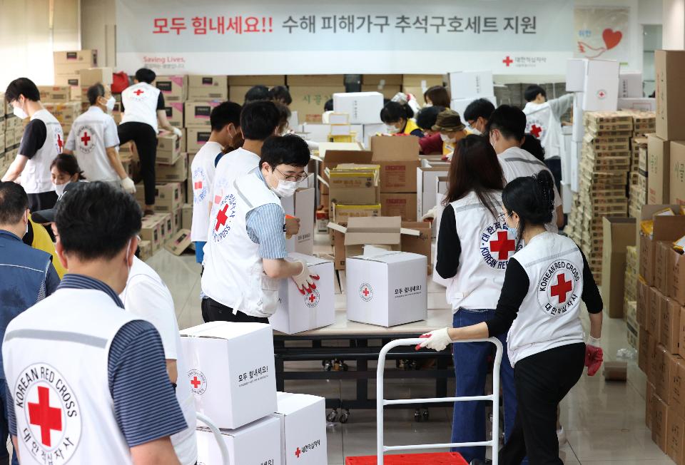 <p>17일 서울 성동구 대한적십자사 서울지사에서 적십자 직원 및 봉사원들이 전국 수해 가구에 전달할 추석구호세트 1,300여 개를 제작해 트럭에 싣고 있다. 구호세트는 마스크, 손소독제, 가공식품 등으로 구성되었다.</p>