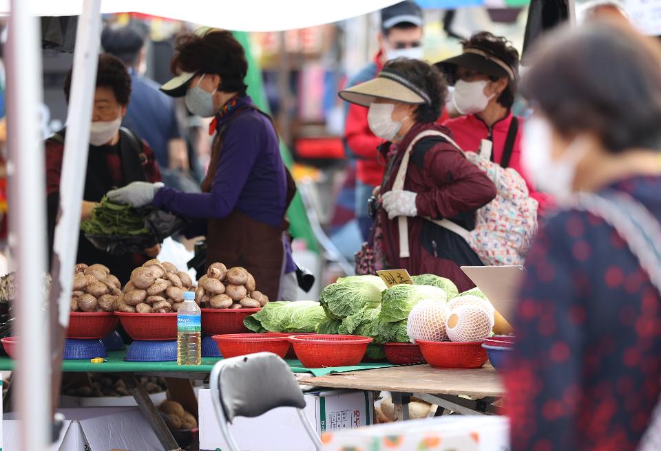 24일 경기도 성남시 모란민속5일장 장터가 열려 추석을 앞두고 시민들이 장을 보고 있다. 이날 코로나19 확산 방지를 위해 성남시 재난안전대책본부 직원들이 나와 시장으로 입장하는 시민들의 열 체크 및 연락처 작성을 도왔다.