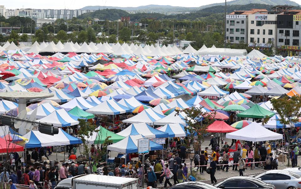 24일 경기도 성남시 모란민속5일장 장터가 열려 추석을 앞두고 시민들이 장을 보고 있다. 이날 코로나19 확산 방지를 위해 성남시 재난안전대책본부 직원들이 나와 시장으로 입장하는 시민들의 열 체크 및 연락처 작성을 도왔다.