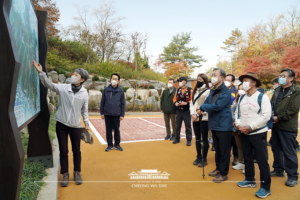 문재인 대통령이 31일 52년 만에 일반에 개방되는 청와대 뒤편 북악산 북측면 둘레길 산행에 앞서 정재숙 문화재청장으로부터 한양도성에 대한 설명을 듣고 있다.