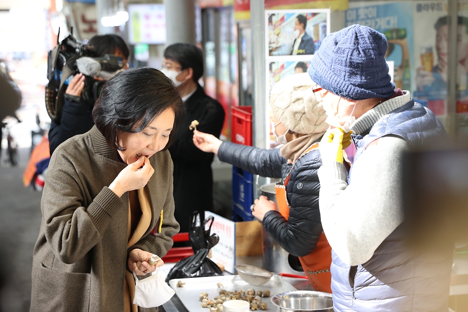 박영선 중소벤처기업부 장관이 14일 오후 소상공인 버팀목자금 수령 현장점검을 위해 서울 노원구 공릉 도깨비시장을 방문, 상인이 건넨 음식을 맛보고 있다.