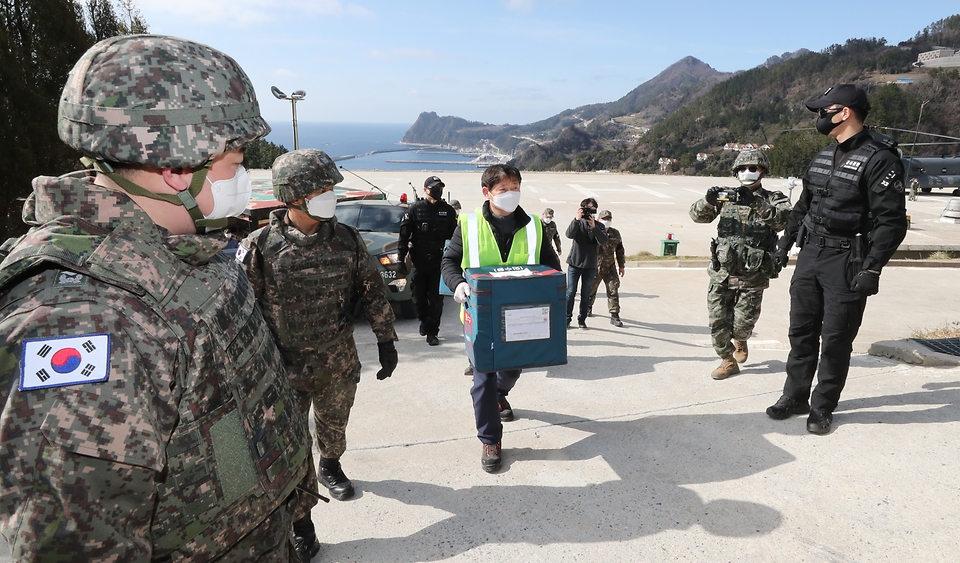 28일 울릉도 해군부대 헬기장에 도착한 코로나19 백신이 군 장병들의 경계 속 울릉군 보건소로 옮겨지고 있다.