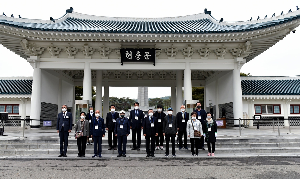 6.25 전사자 신원 확인 포상금 소급지급 행사에 참여한 유가족들이 현충문 앞에서 기념촬영을 하고 있다.
