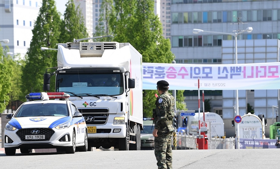 12일 충북 오창 물류창고에서 열린 ‘모더나 백신 수송 모의훈련’에서 모의 백신을 실은 수송 트럭이 군경의 호위 속에 창고에 도착하고 있다. (출처=국방일보)