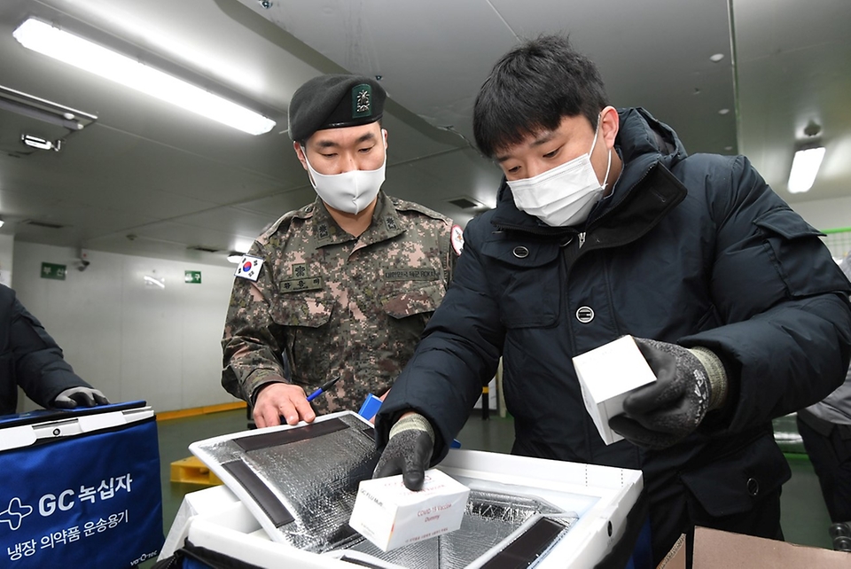 12일 오전 충북 오창 물류창고에서 코로나19 백신수송지원본부 주관으로 열린 ‘모더나 백신 수송 모의훈련’ 중 군 감독관과 민간업체 담당자가 모의 백신을 지역 거점창고로 수송하기 위해 냉장용 이동 상자에 소분하고 있다. (출처=국방일보)