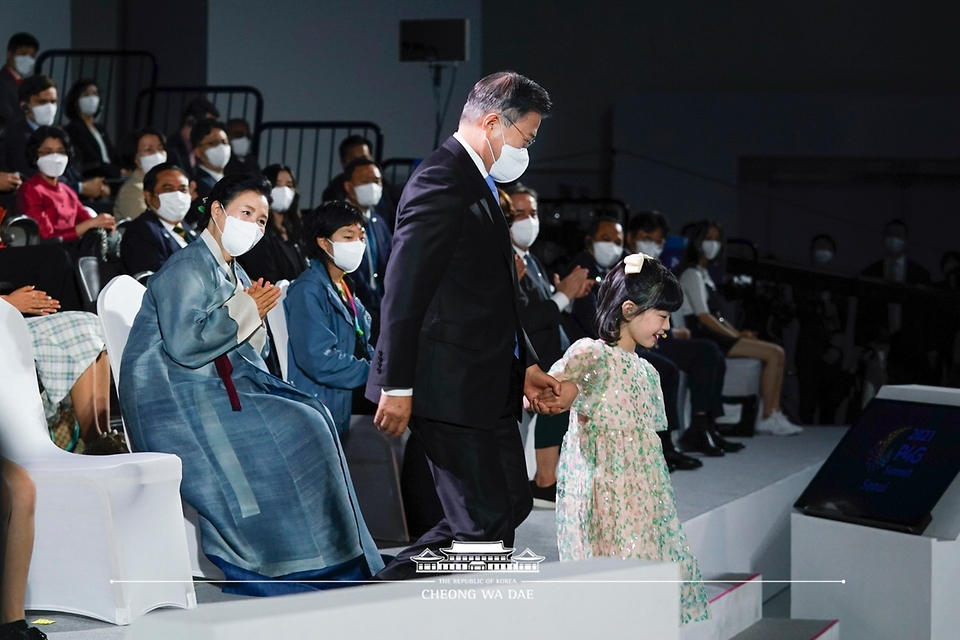 문재인 대통령이 30일 오후 서울 동대문디자인플라자에서 열린 ‘2021 P4G 서울 녹색미래 정상회의’ 개회식에서 어린이의 안내를 받으며 연단으로 향하고 있다.