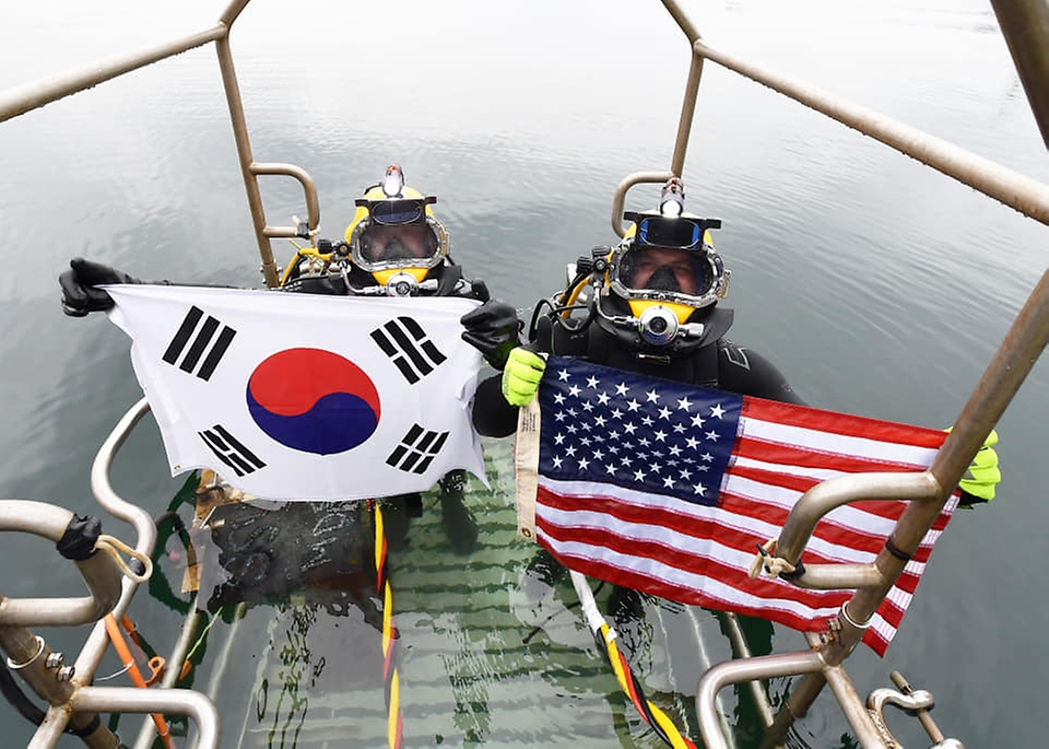 15일 경남 창원 진해만 일대에서 열린 한미 연합 구조전 훈련에서 양국 구조대원들이 손상 함정 긴급 복구 훈련 종료 후 자국 국기를 들어보이고 있다. (출처=대한민국 해군 페이스북)