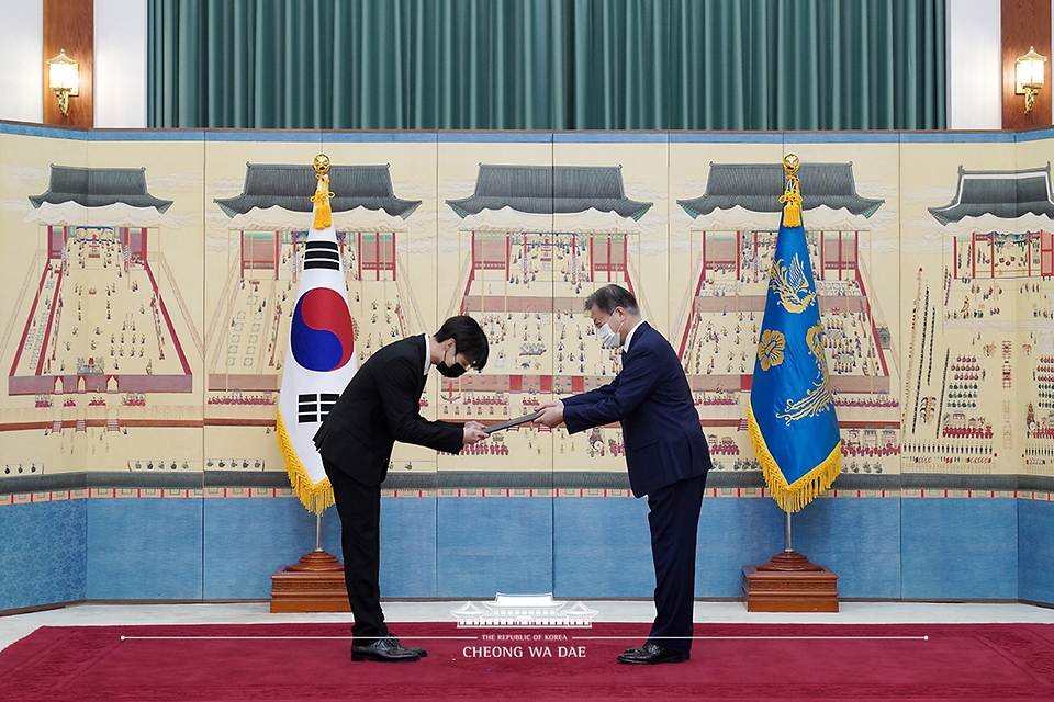 문재인 대통령이 14일 청와대에서 열린 미래세대와 문화를 위한 대통령 특별사절 임명장 수여식에서 아이돌 그룹 방탄소년단(BTS) 멤버 정국(전정국)에게 임명장을 수여하고 외교여권과 기념품을 전달하고 있다.