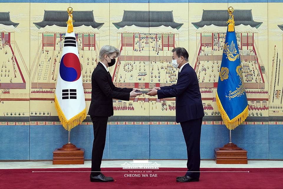 문재인 대통령이 14일 청와대에서 열린 미래세대와 문화를 위한 대통령 특별사절 임명장 수여식에서 아이돌 그룹 방탄소년단(BTS) 멤버 슈가(민윤기)에게 임명장을 수여하고 외교여권과 기념품을 전달하고 있다.