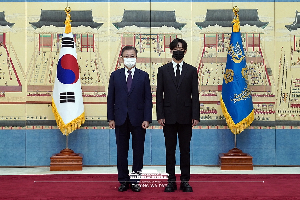 문재인 대통령이 14일 청와대에서 열린 미래세대와 문화를 위한 대통령 특별사절 임명장 수여식에서 아이돌 그룹 방탄소년단(BTS) 멤버 뷔(김태형)에게 임명장을 수여하고 기념촬영을 하고 있다.