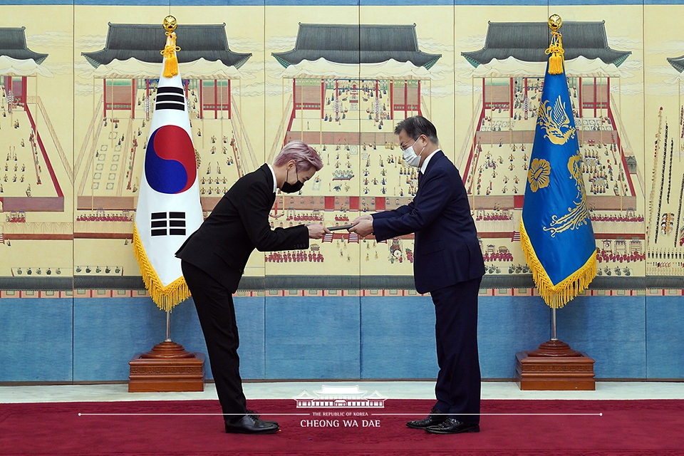 문재인 대통령이 14일 청와대에서 열린 미래세대와 문화를 위한 대통령 특별사절 임명장 수여식에서 아이돌 그룹 방탄소년단(BTS) 멤버 제이홉(정호석)에게 임명장을 수여하고 외교여권과 기념품을 전달하고 있다.
