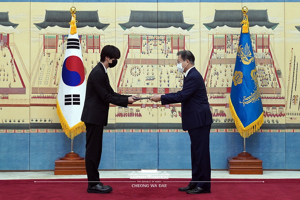 문재인 대통령이 14일 청와대에서 열린 미래세대와 문화를 위한 대통령 특별사절 임명장 수여식에서 아이돌 그룹 방탄소년단(BTS) 멤버 진(김석진)에게 임명장을 수여하고 외교여권과 기념품을 전달하고 있다.