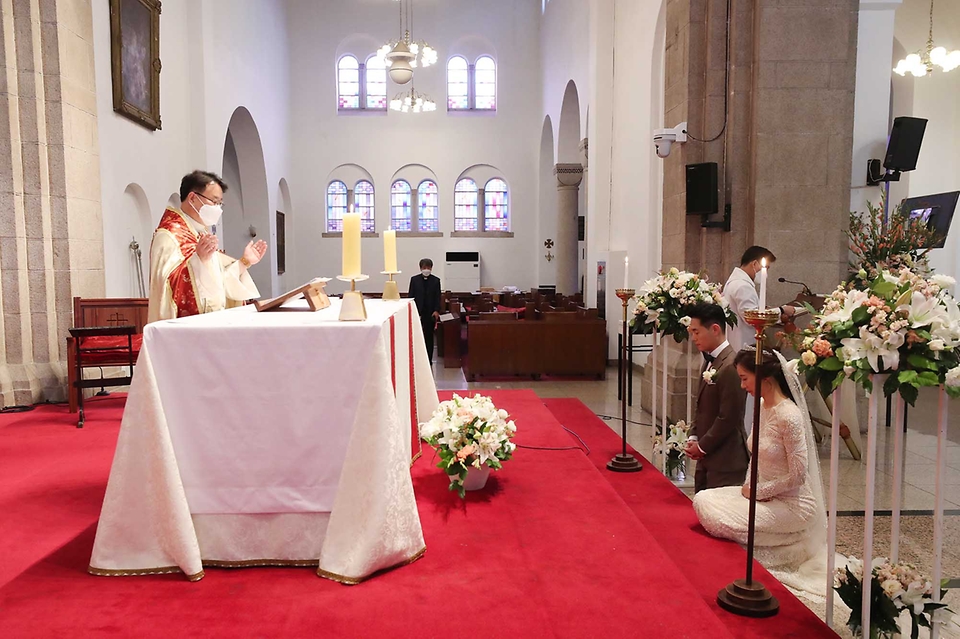 <p>신종 코로나바이러스 감염증(코로나19)이 펜데믹(세계적 대유행)이 지속되는 가운데 16일 오후 서울 한 성당에서 결혼식이 열리고 있다. 이날 예식은 방역수칙과 사회적 거리를 준수하며 안전하게 진행됐다.</p>