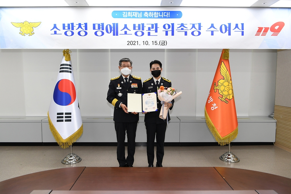 신열우 소방청장이 15일 오후 세종시 소방청에서 명예소방관으로 위촉된 가수 김희재 씨와 함께 기념촬영을 하고 있다.