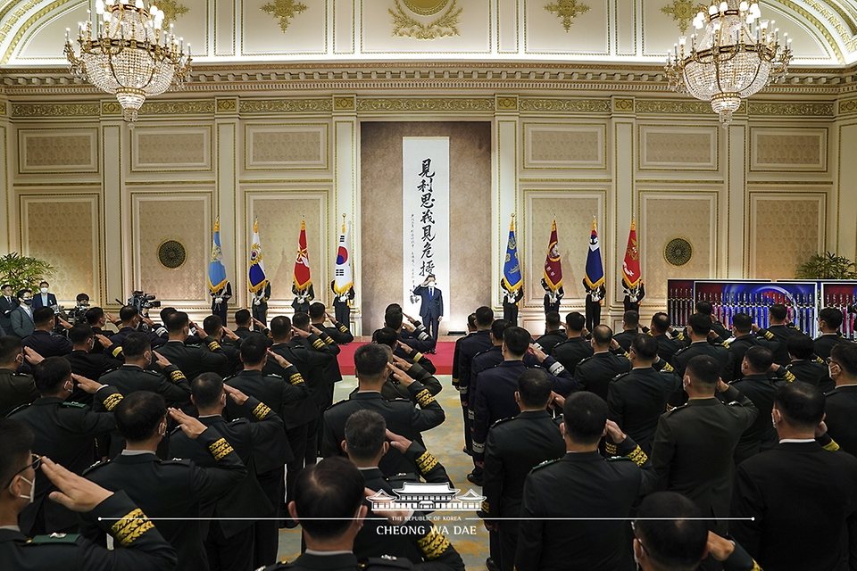 문재인 대통령이 16일 청와대 영빈관에서 열린 육군, 해군, 해병대, 공군 준장 진급자 삼정검 수여식에서 진급 장성의 경례를 받고 있다.
