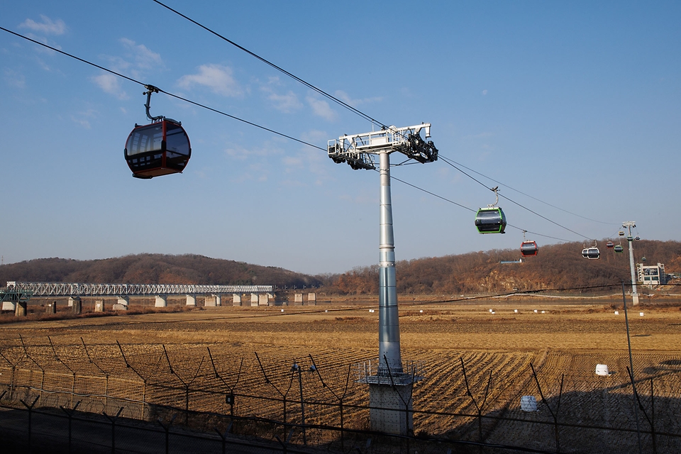 <p>DMZ 평화의 길이 개방됐다. 정부는 20일부터 ‘디엠지(DMZ) 평화의 길’ 강화, 김포, 고양, 파주, 화천, 양구, 고성 등 7개 태마노선을 우선 개방했다. 이번 개방하는 7개 테마노선은 무료로 운영된다. 참가자는 11일부터 한국관광공사 디엠지(DMZ) 평화의 길 누리집과 걷기 여행길 정보제공 모바일앱 ‘두루누비’를 통해 사전 예약할 수 있다. </p>
<p>사진은 민통선 지역을 오가는 임진각 평화 곤돌라