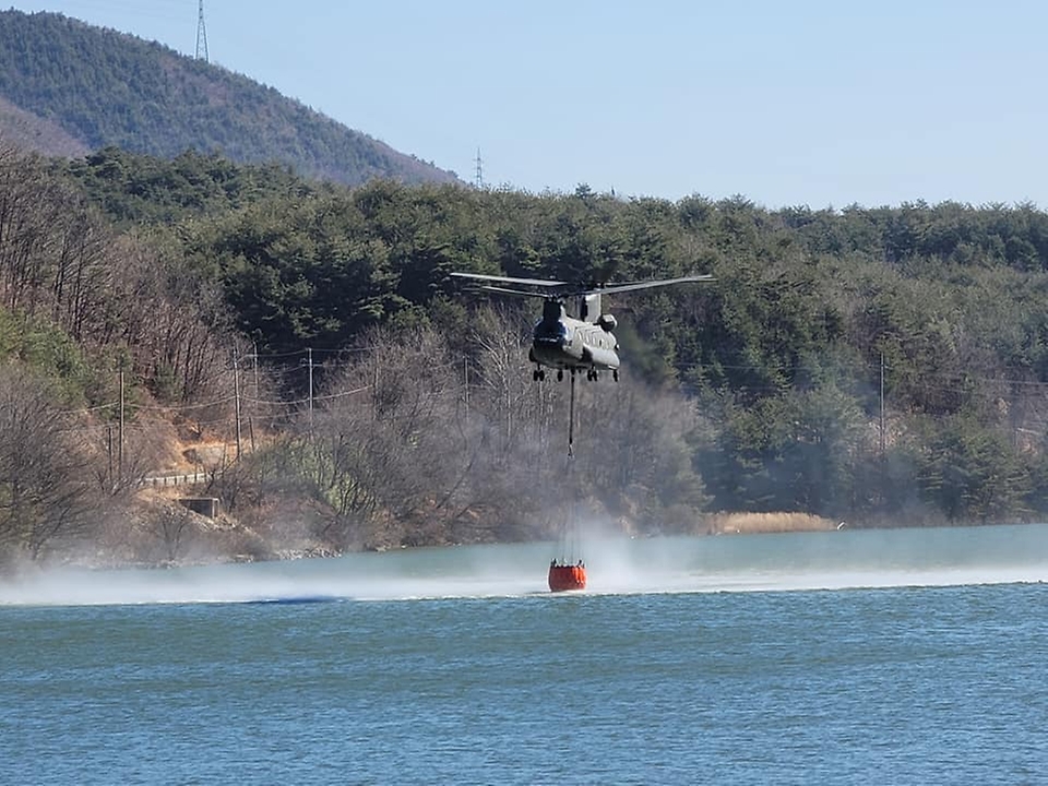 6일 산불 진화를 위해 투입된 육군 치누크 헬기가 저수지 상공에서 급수하고 있다.