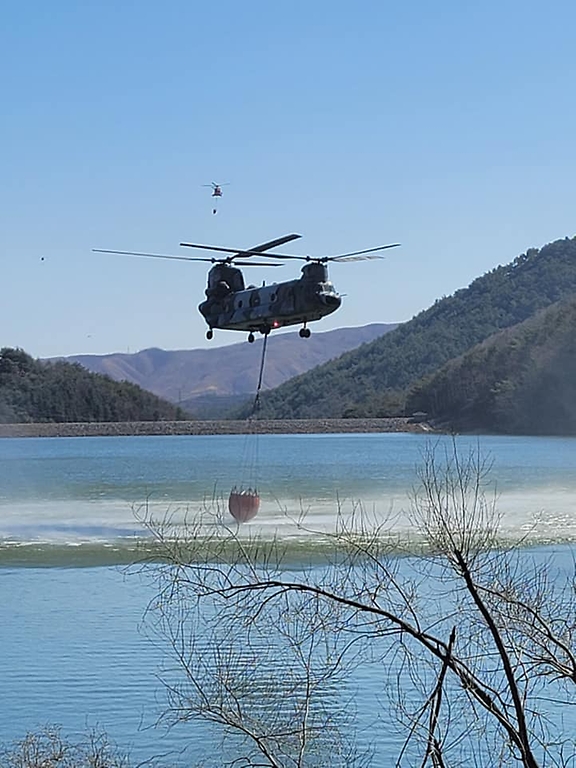 6일 산불 진화를 위해 투입된 육군 치누크 헬기가 저수지 상공에서 급수하고 있다.