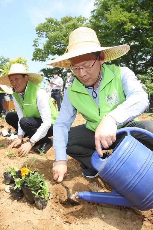 김인중 농림축산식품부 차관이 13일 서울 여의도 국회의사당 헌정기념관 근처에 조성된 ‘국회 생생텃밭’ 개장식 행사에 참석해 모종을 심고 있다.