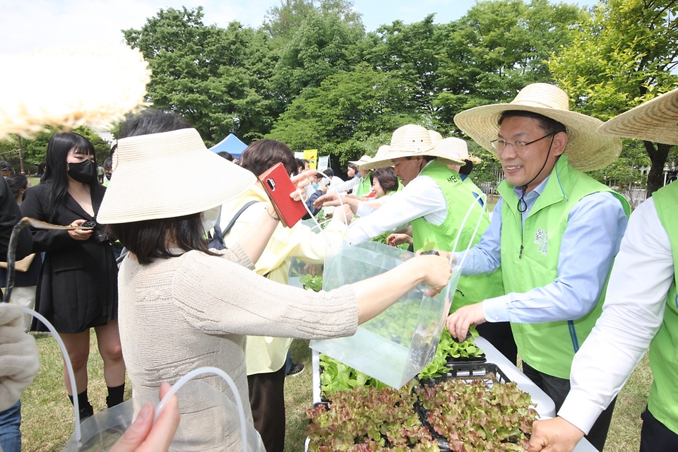 김인중 농림축산식품부 차관이 13일 서울 여의도 국회의사당 헌정기념관 근처에 조성된 ‘국회 생생텃밭’ 개장식 행사에 참석해 참석자들에게 모종을 나눠주고 있다.